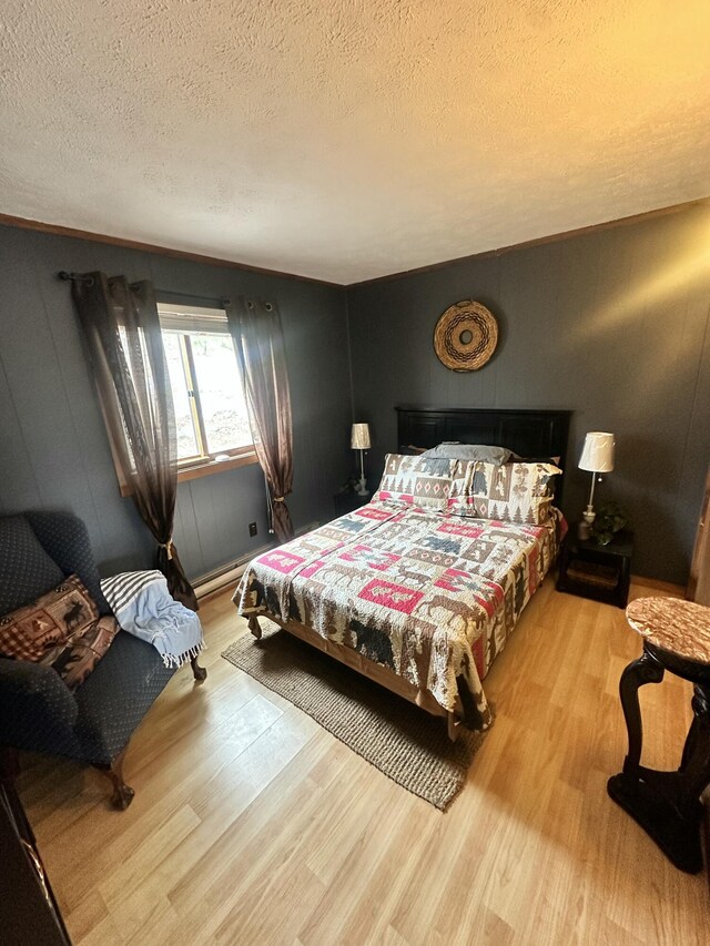 bedroom featuring a textured ceiling and wood finished floors