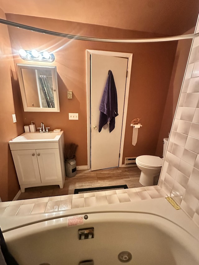 full bathroom featuring toilet, vanity, wood finished floors, and baseboards