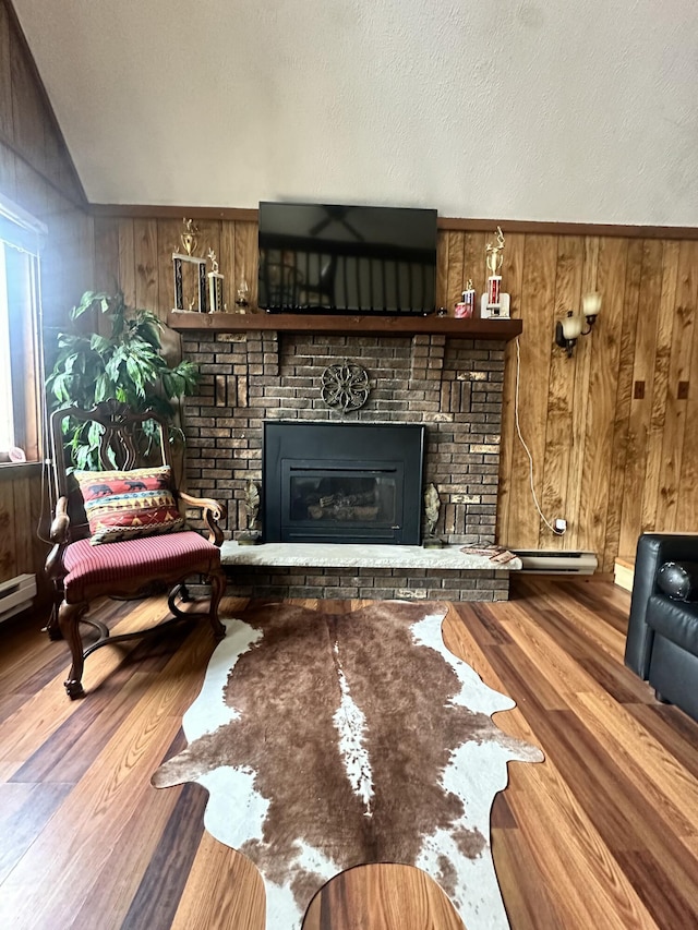 living area featuring wood finished floors, wood walls, a brick fireplace, and vaulted ceiling