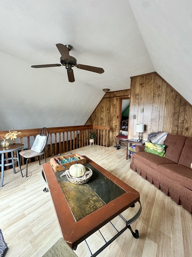 additional living space with wooden walls, ceiling fan, vaulted ceiling, and wood finished floors