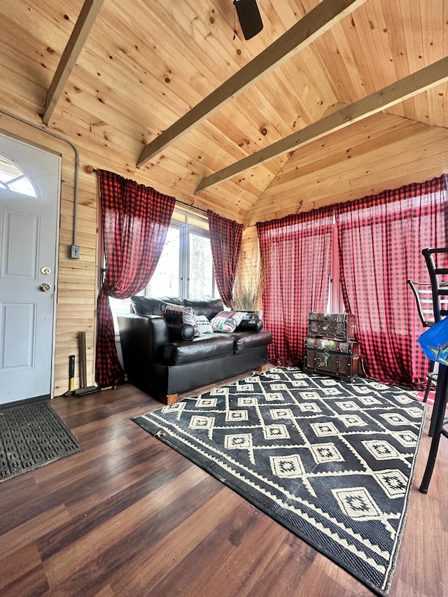 living area with wooden walls, vaulted ceiling with beams, wood finished floors, and wood ceiling