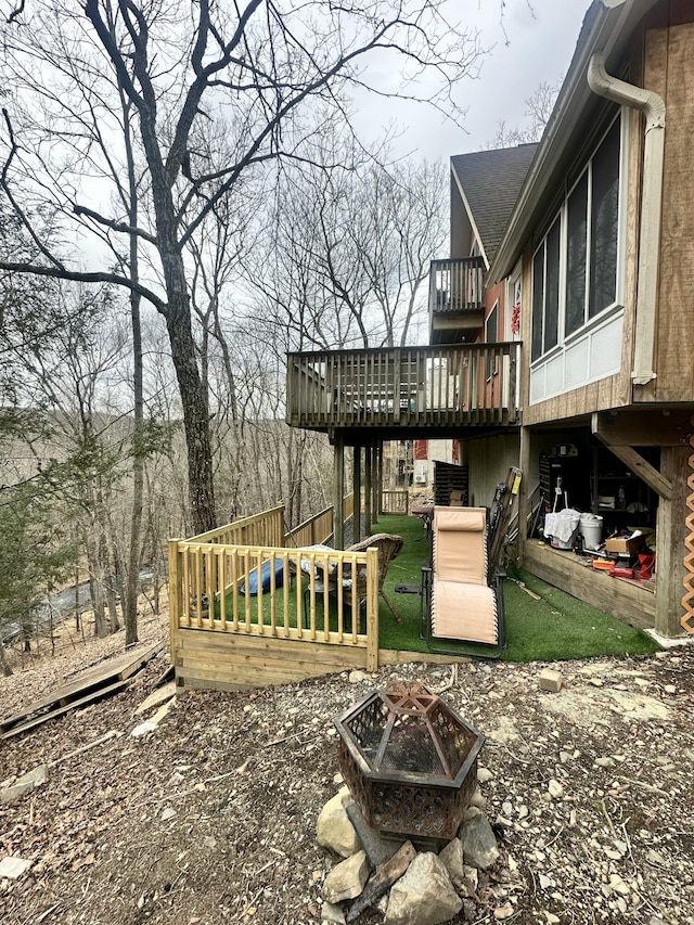 view of yard featuring stairs, a fire pit, and a wooden deck