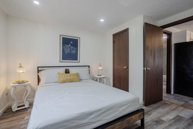 bedroom featuring wood finished floors and recessed lighting