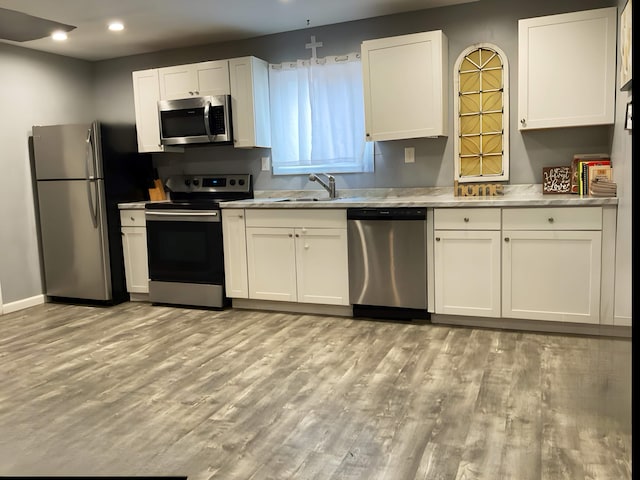 106 Lakota Rd, East Stroudsburg, PA 18302 - kitchen featuring appliances with stainless steel finishes, a sink, light wood-style floors, white cabinetry, and recessed lighting