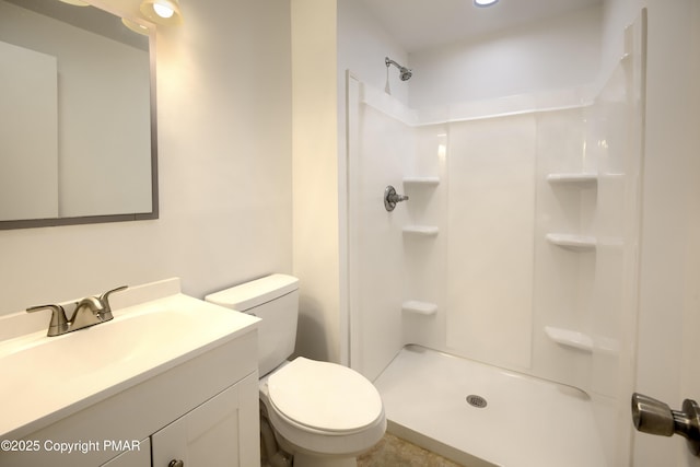 bathroom featuring vanity, toilet, and a shower