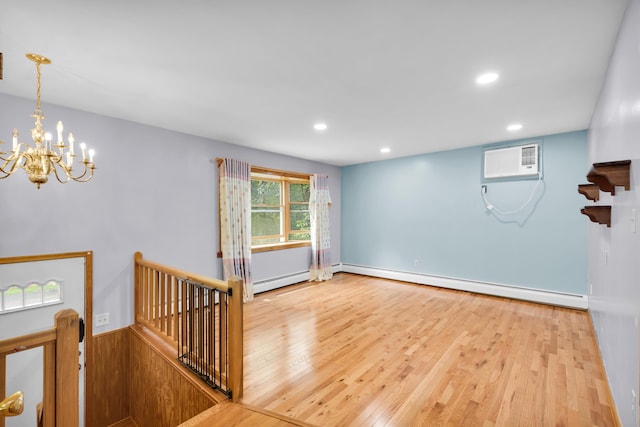 4620 Buck Valley Cir E, Stroudsburg, PA 18301 - spare room featuring baseboard heating, a wall mounted AC, a chandelier, wood finished floors, and a baseboard radiator