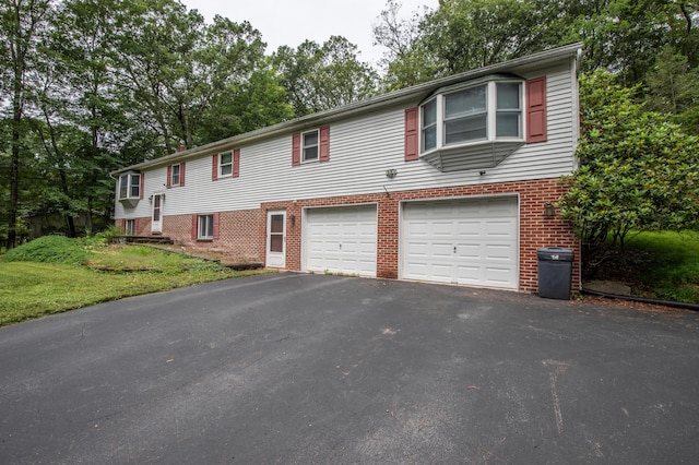 4620 Buck Valley Cir E, Stroudsburg, PA 18301 - raised ranch featuring asphalt driveway, a garage, brick siding, and a front lawn