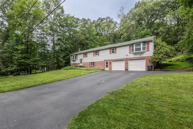 4620 Buck Valley Cir E, Stroudsburg, PA 18301 - split foyer home featuring driveway, a garage, brick siding, a front yard, and view of wooded area