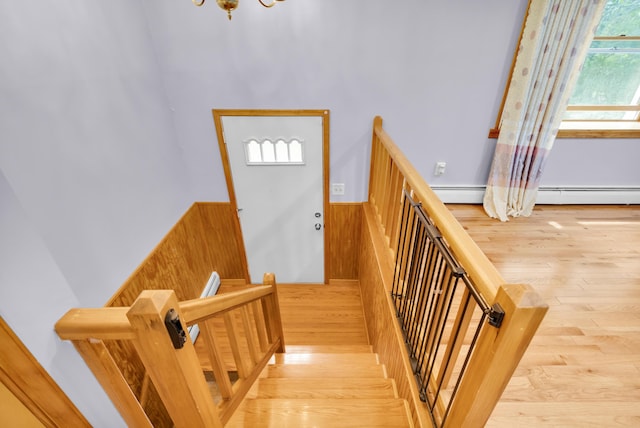 4620 Buck Valley Cir E, Stroudsburg, PA 18301 - stairs featuring wood finished floors, wainscoting, a baseboard heating unit, a chandelier, and wood walls
