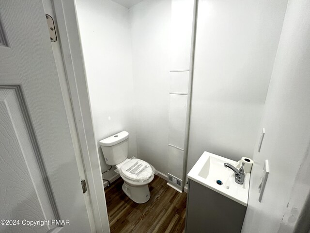 bathroom featuring toilet, visible vents, wood finished floors, and vanity