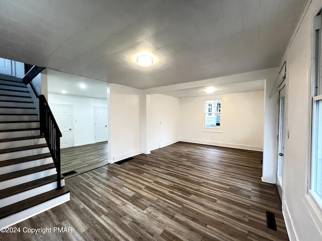 interior space featuring visible vents, dark wood finished floors, stairway, and baseboards