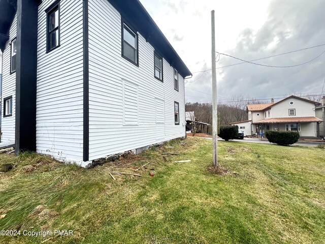 view of property exterior with a lawn