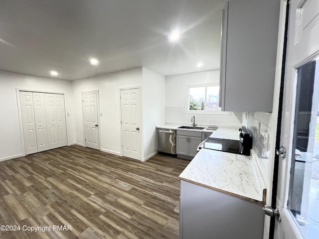 kitchen with dark wood-style flooring, gray cabinetry, a sink, range, and dishwasher