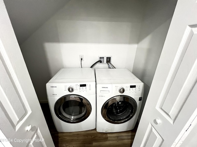 laundry area with laundry area, washing machine and dryer, and wood finished floors