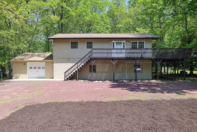 289 Towamensing Trl, Albrightsville, PA 18210 - view of front of property with a wooden deck, a garage, dirt driveway, stairway, and stucco siding