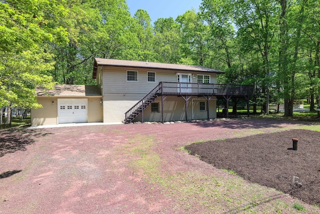 289 Towamensing Trl, Albrightsville, PA 18210 - view of front of house featuring a wooden deck, stairway, a garage, driveway, and stucco siding