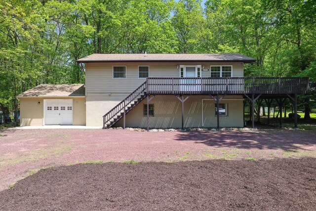 289 Towamensing Trl, Albrightsville, PA 18210 - view of front of property with a wooden deck, a garage, dirt driveway, stairway, and stucco siding
