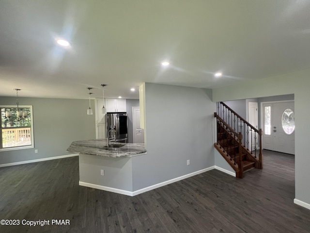 kitchen featuring dark wood-style floors, stainless steel refrigerator with ice dispenser, and baseboards