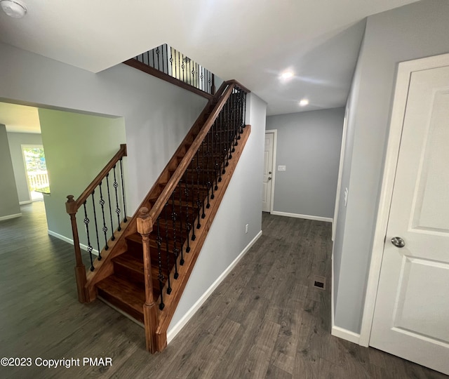 staircase with baseboards and wood finished floors