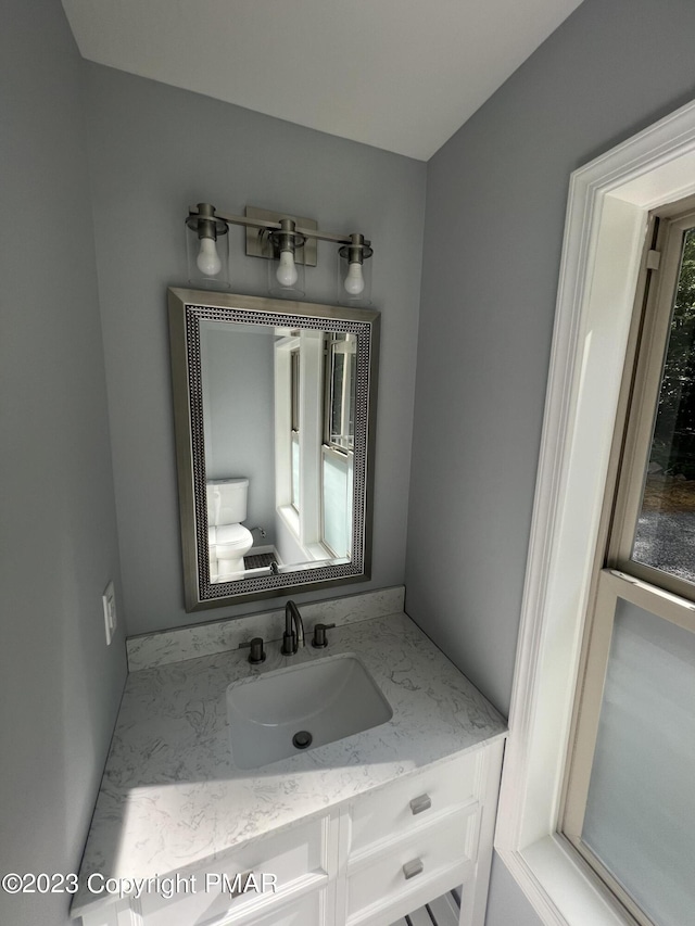 half bathroom with vanity and toilet