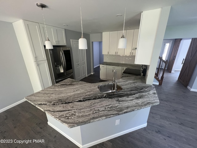 kitchen with backsplash, dark wood finished floors, a sink, and stainless steel fridge with ice dispenser