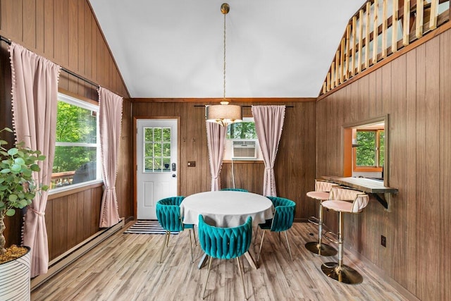 322 Clubhouse Dr, East Stroudsburg, PA 18302 - dining space featuring lofted ceiling, wood finished floors, wooden walls, cooling unit, and baseboard heating