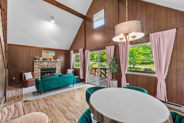 322 Clubhouse Dr, East Stroudsburg, PA 18302 - dining space with wood walls, high vaulted ceiling, baseboard heating, wood finished floors, and a fireplace