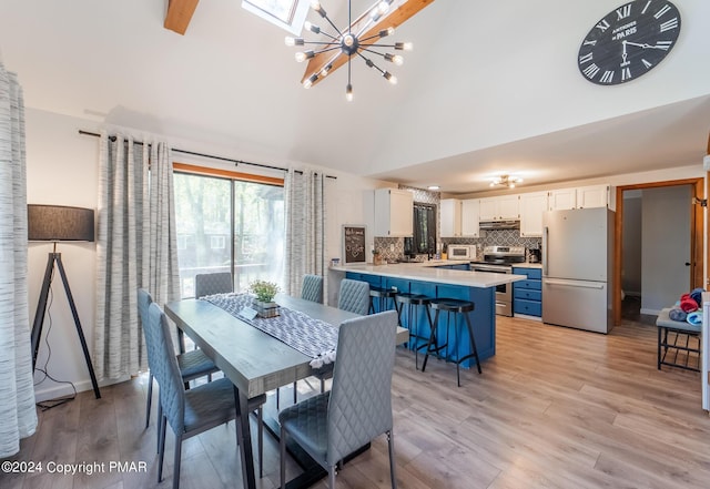 dining area featuring light wood-style flooring, baseboards, high vaulted ceiling, and a chandelier