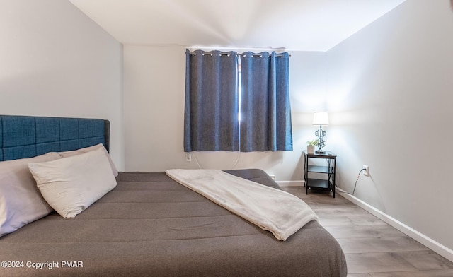 bedroom with baseboards and wood finished floors