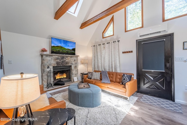 living area with beamed ceiling, a stone fireplace, wood finished floors, high vaulted ceiling, and a wall mounted AC