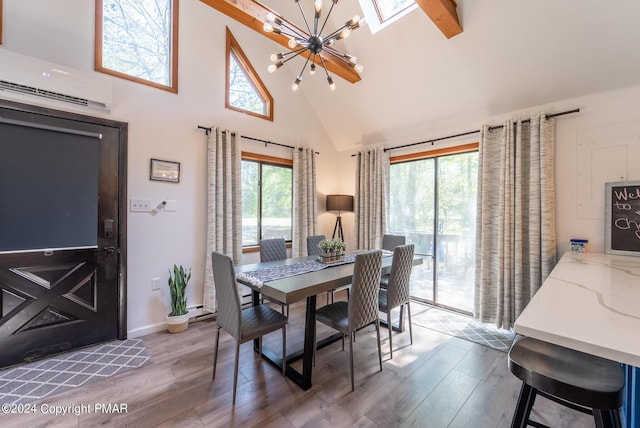 dining room featuring wood finished floors, a healthy amount of sunlight, a wall mounted air conditioner, and a chandelier