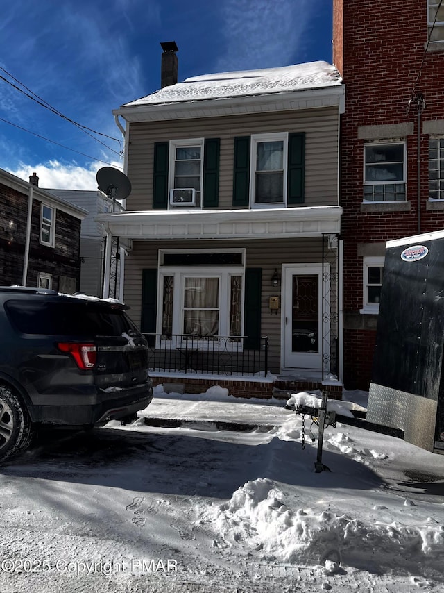 view of front of home with a porch and a chimney