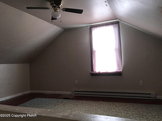 additional living space featuring a baseboard radiator, lofted ceiling, and hardwood / wood-style floors