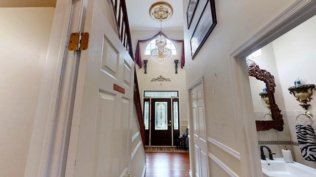 603 Washington Xing, East Stroudsburg, PA 18301 - doorway to outside with a high ceiling, a wainscoted wall, a chandelier, and wood finished floors