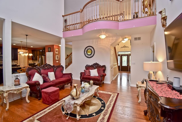 603 Washington Xing, East Stroudsburg, PA 18301 - living room featuring a chandelier, stairway, wood finished floors, and a high ceiling