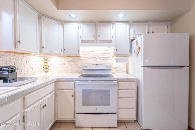 kitchen with white cabinetry, light tile patterned floors, white appliances, and tasteful backsplash