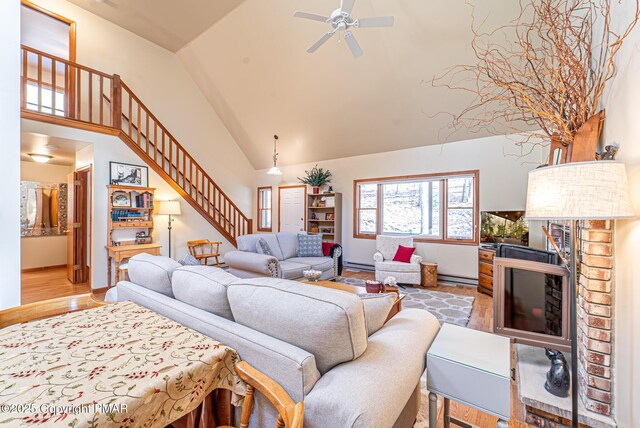 living room with a baseboard radiator, high vaulted ceiling, ceiling fan, and light wood-type flooring