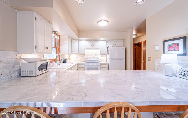 kitchen featuring white cabinetry, white appliances, sink, and backsplash