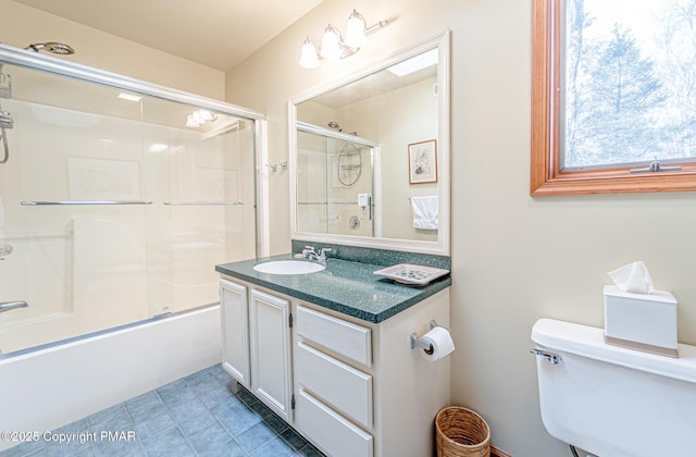 full bathroom featuring vanity, combined bath / shower with glass door, tile patterned floors, and toilet