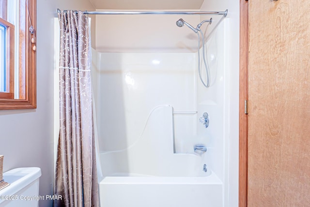 bathroom with toilet and shower / bath combo with shower curtain