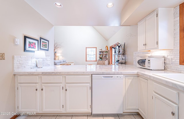 kitchen with white appliances, white cabinetry, decorative backsplash, vaulted ceiling, and kitchen peninsula