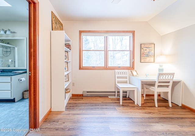 interior space with baseboard heating, vaulted ceiling, and light hardwood / wood-style flooring