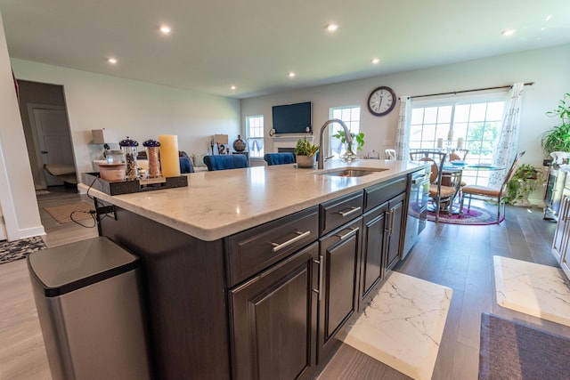 kitchen featuring a sink, recessed lighting, dishwasher, light wood-style flooring, and a kitchen island with sink