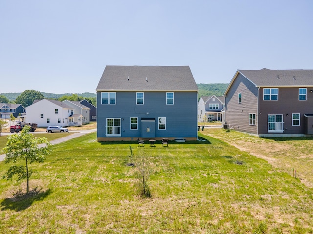 rear view of property featuring a residential view and a yard