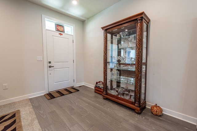 entryway with dark wood-style floors and baseboards