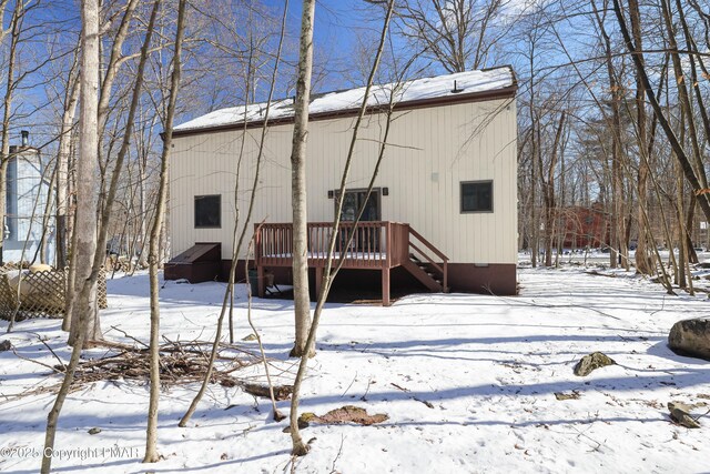 snow covered house with a wooden deck