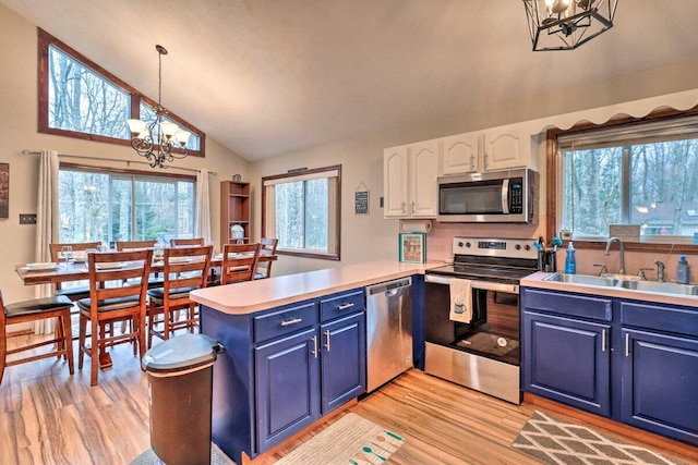 54 Spencer Ln, Albrightsville, PA 18210 - kitchen with stainless steel appliances, a chandelier, blue cabinetry, light wood-style floors, and high vaulted ceiling