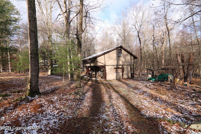 exterior space with driveway and a wooded view