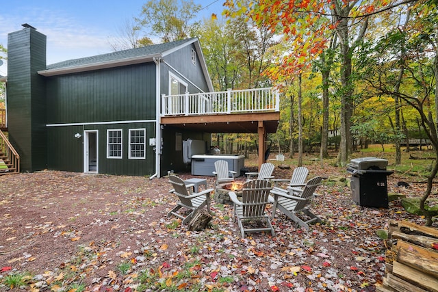 rear view of house with a wooden deck, a chimney, an outdoor fire pit, and stairs