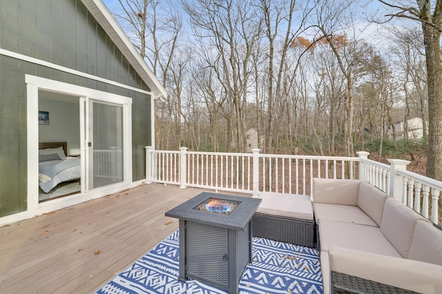 wooden deck with an outdoor living space with a fire pit